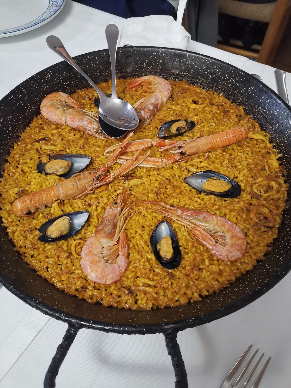 Traditional Valencian paella with shrimp saffron rice in a wide pan