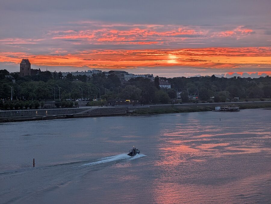 Sunset over Warsaw seen from the Slasko-Dabrowski Bridge with a boat on the Vistula