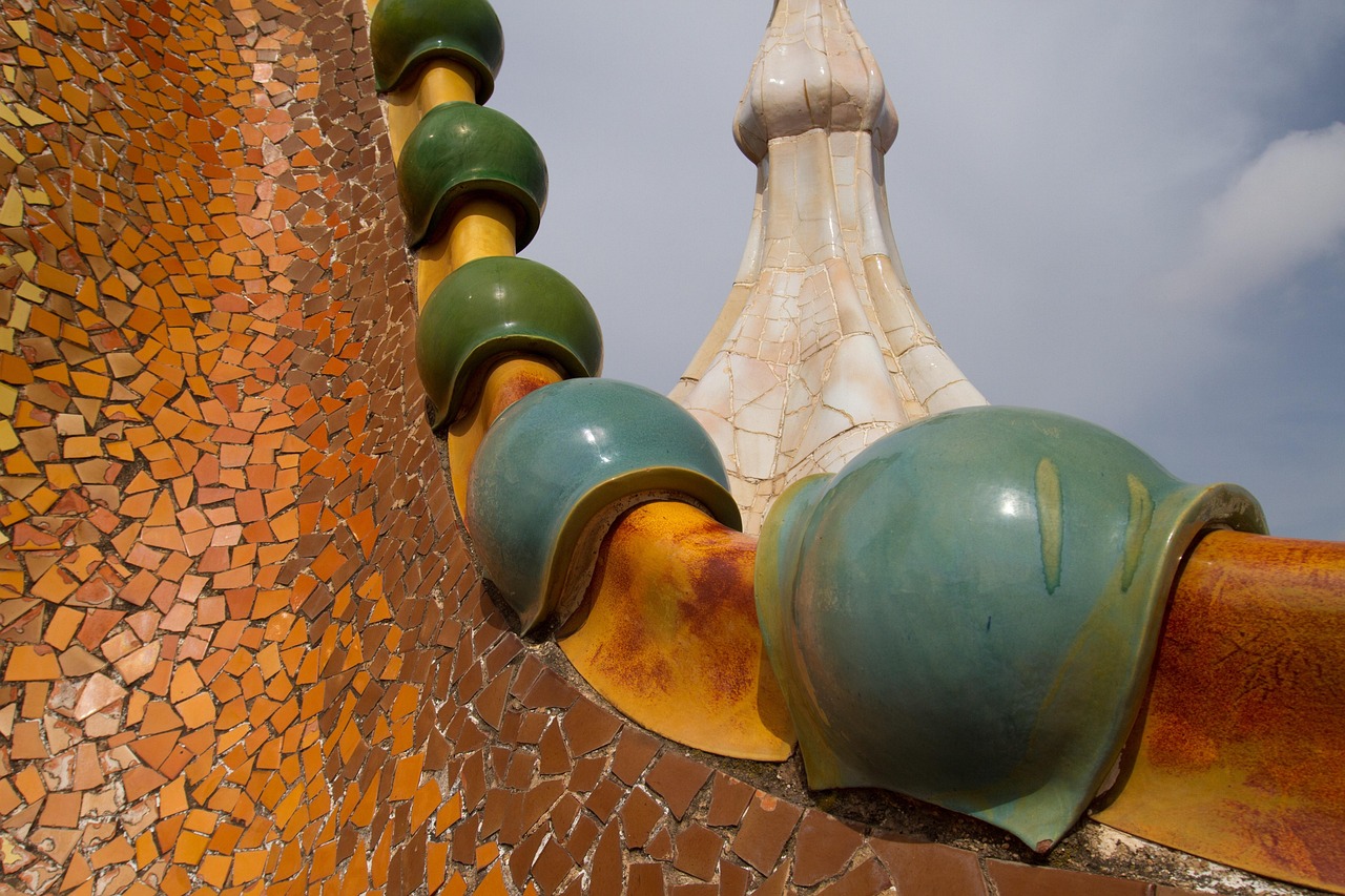 Close-up of Gaudi style rooftop chimneys covered in mosaic tiles on a Barcelona rooftop