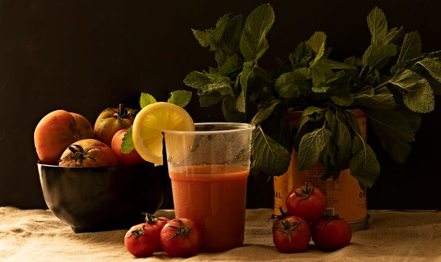 Fresh gazpacho in a glass bowl with tomatoes and mint leaves