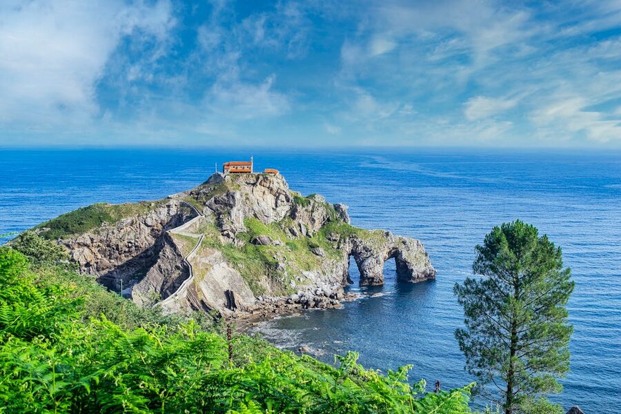 Gaztelugatxe island coastline with clear blue waters of the Bay of Biscay