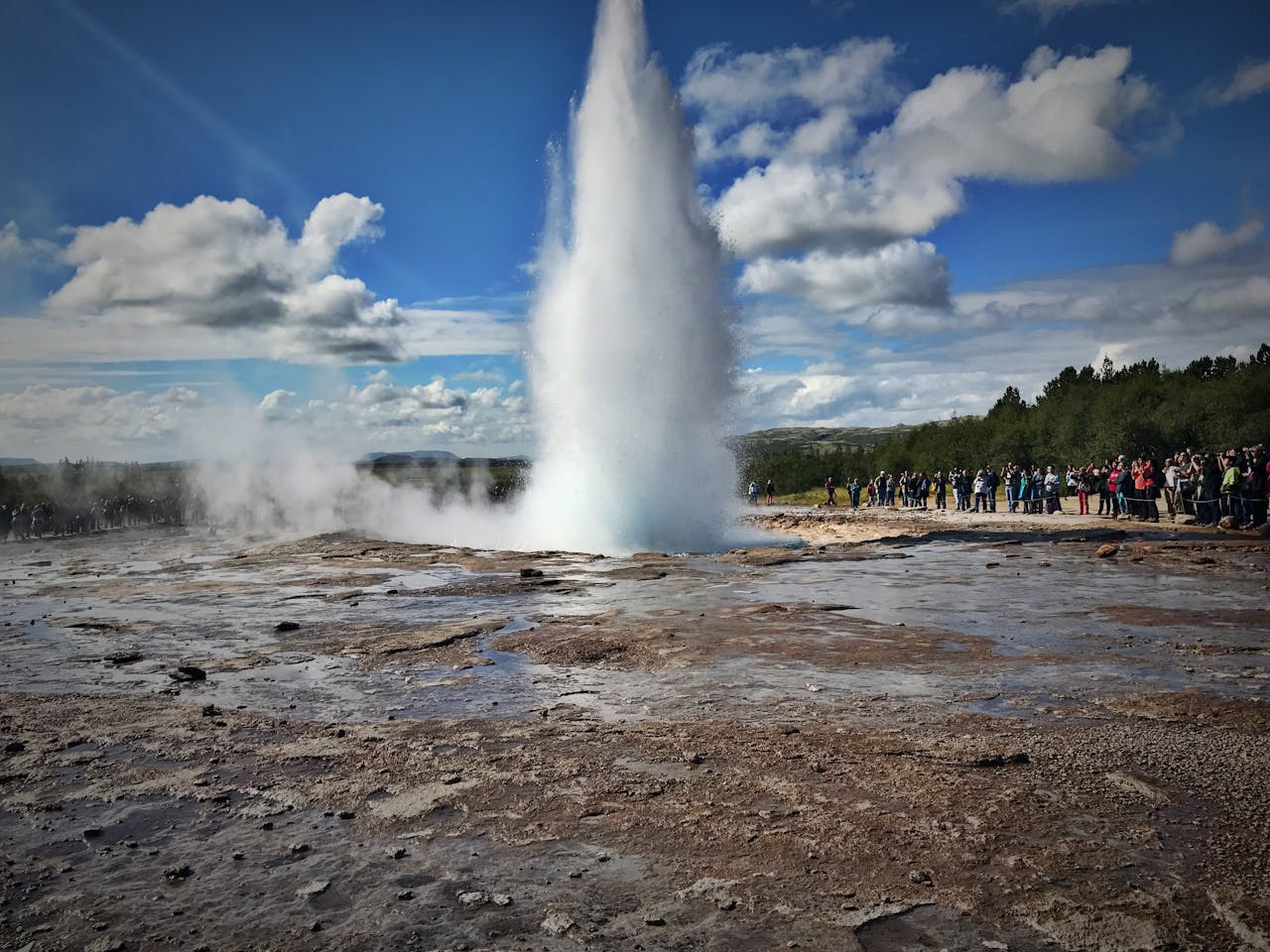 Group of travelers watching a geyser erupt at the Geysir geothermal area Iceland
