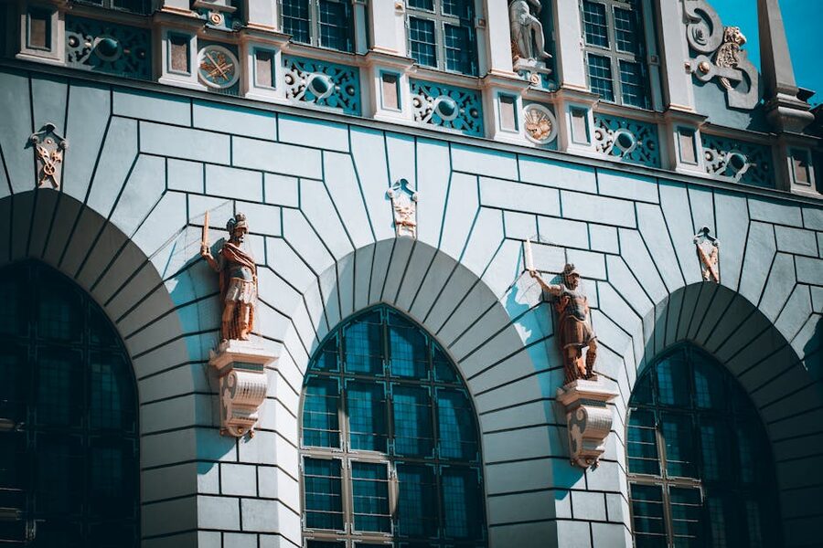 Gdansk old town facade with statues between arched windows