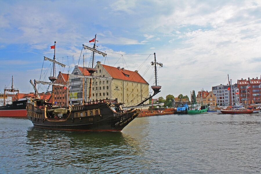 Tall wooden ship with red sails moored in Gdańsk harbour