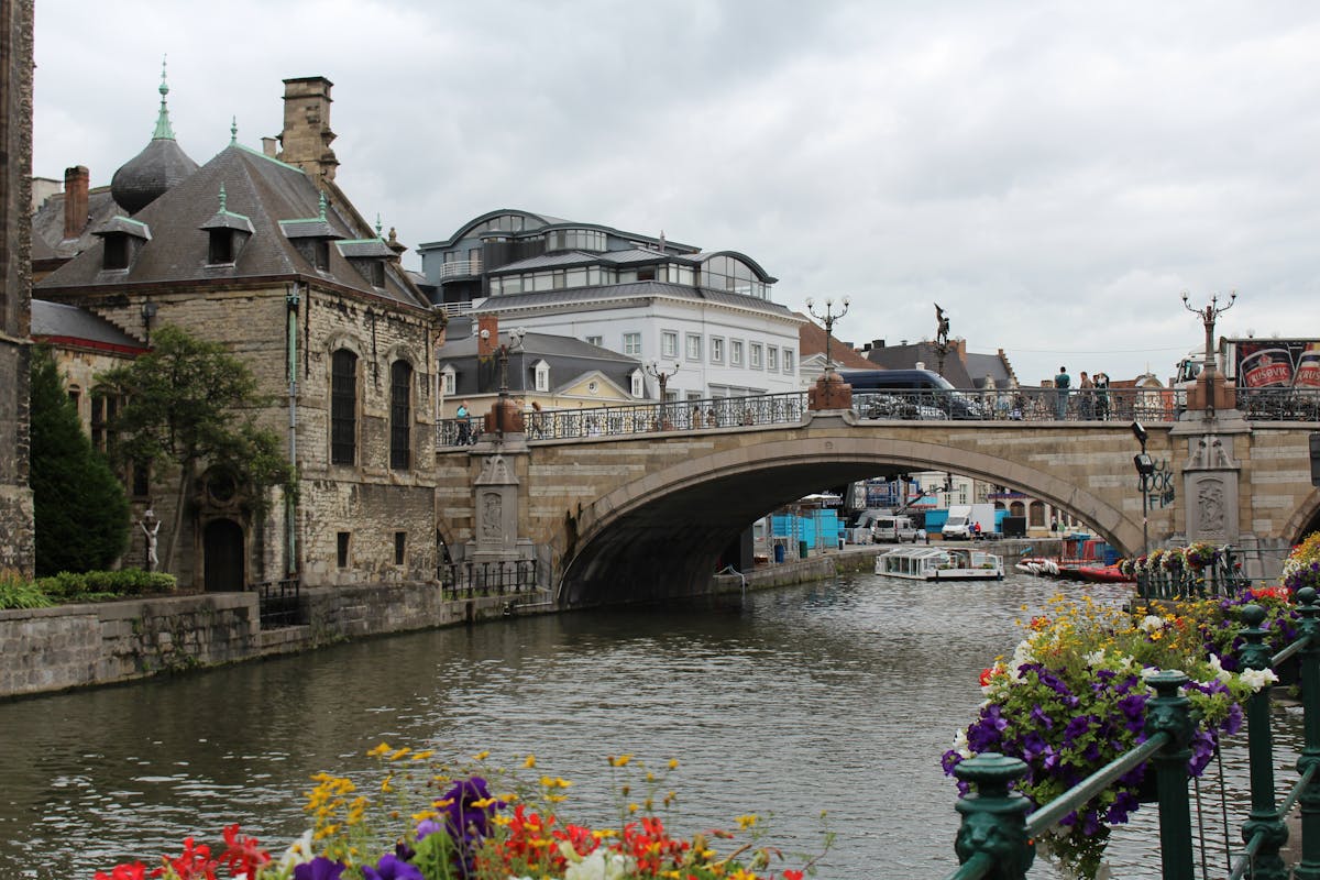 Charming canal in Ghent Belgium with historic bridge and flowers