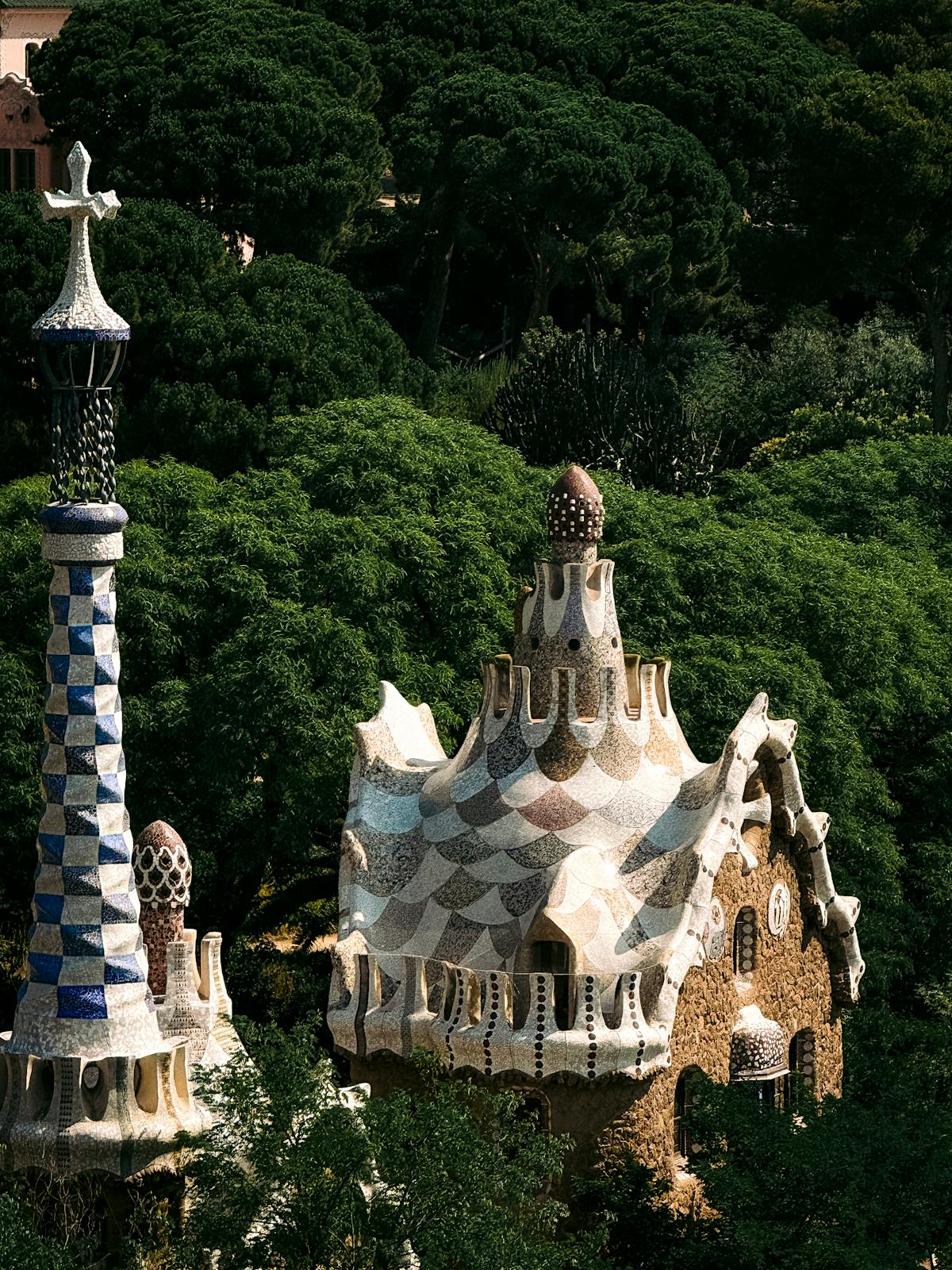 Charming gingerbread-style architectural structures surrounded by greenery at Park Guell
