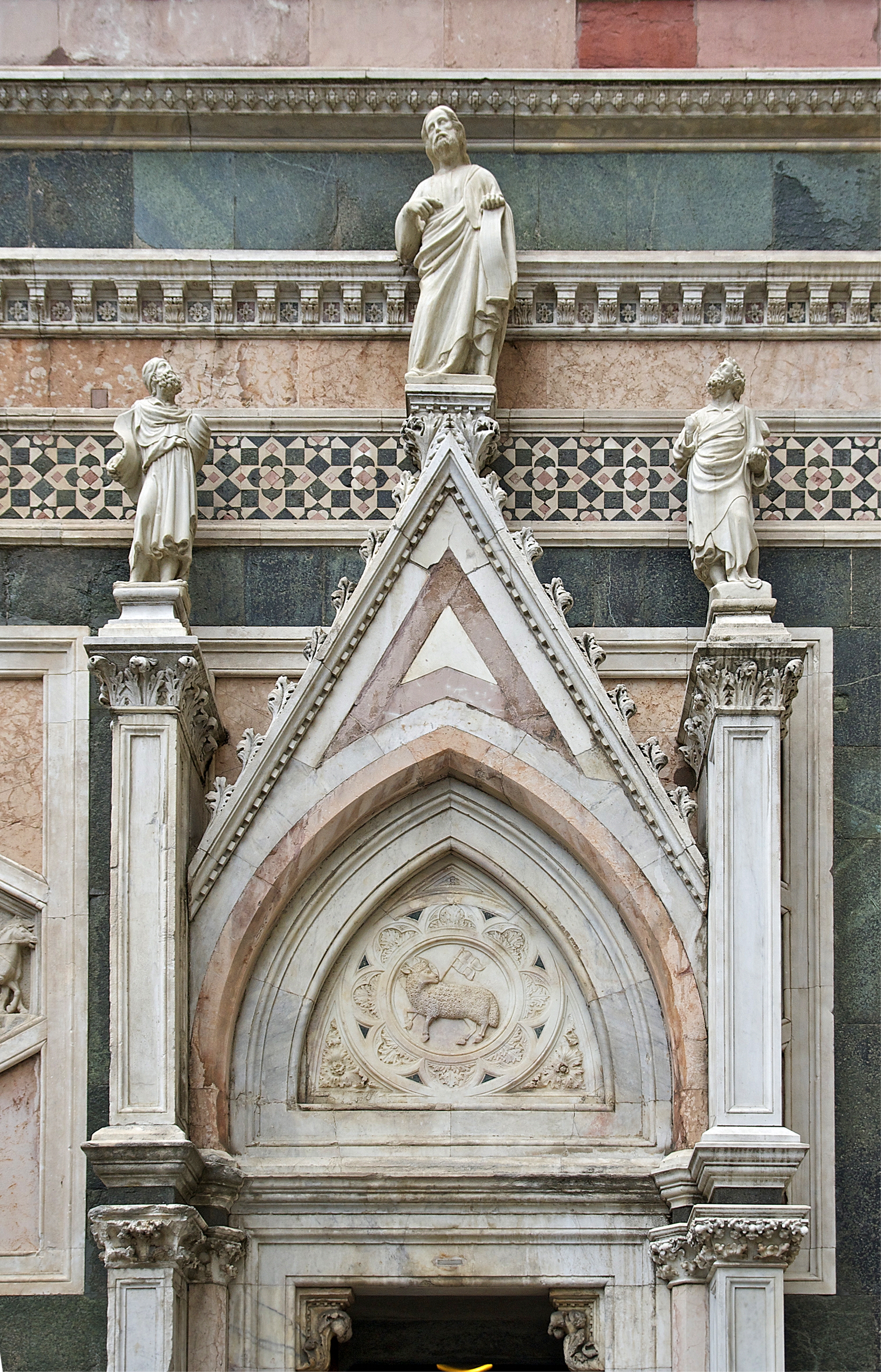 Upper section of Giotto Campanile showing Gothic windows and marble relief sculptures