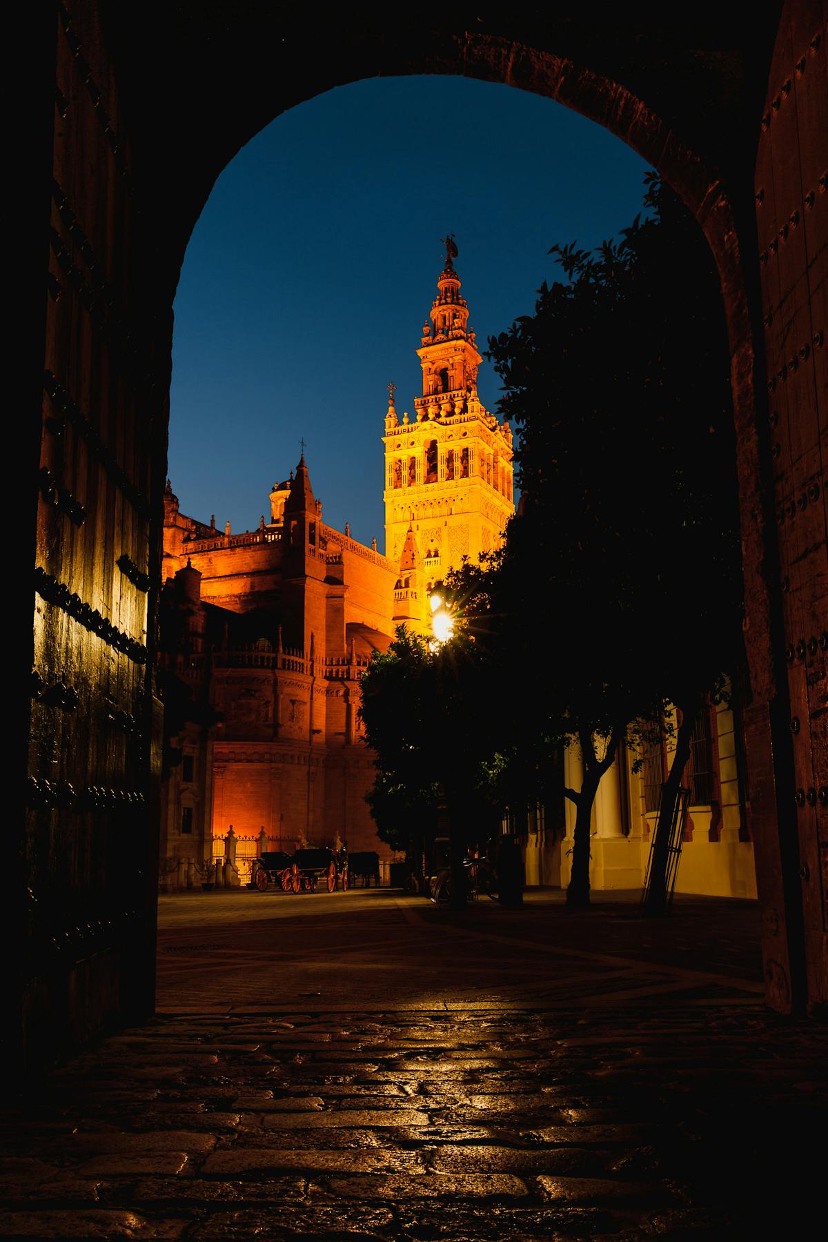 La Giralda Tower in Seville illuminated at night seen through an archway
