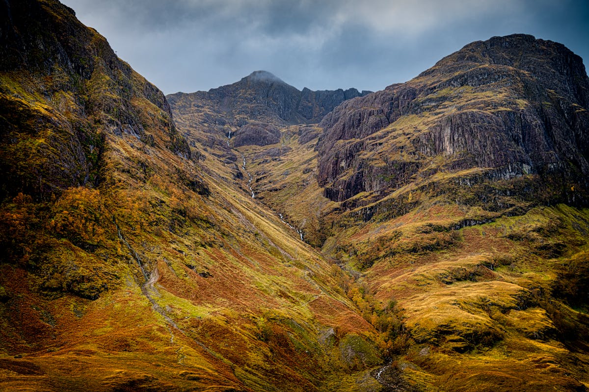 Snow-capped mountain peaks in Glencoe, Scotland under a bright sky