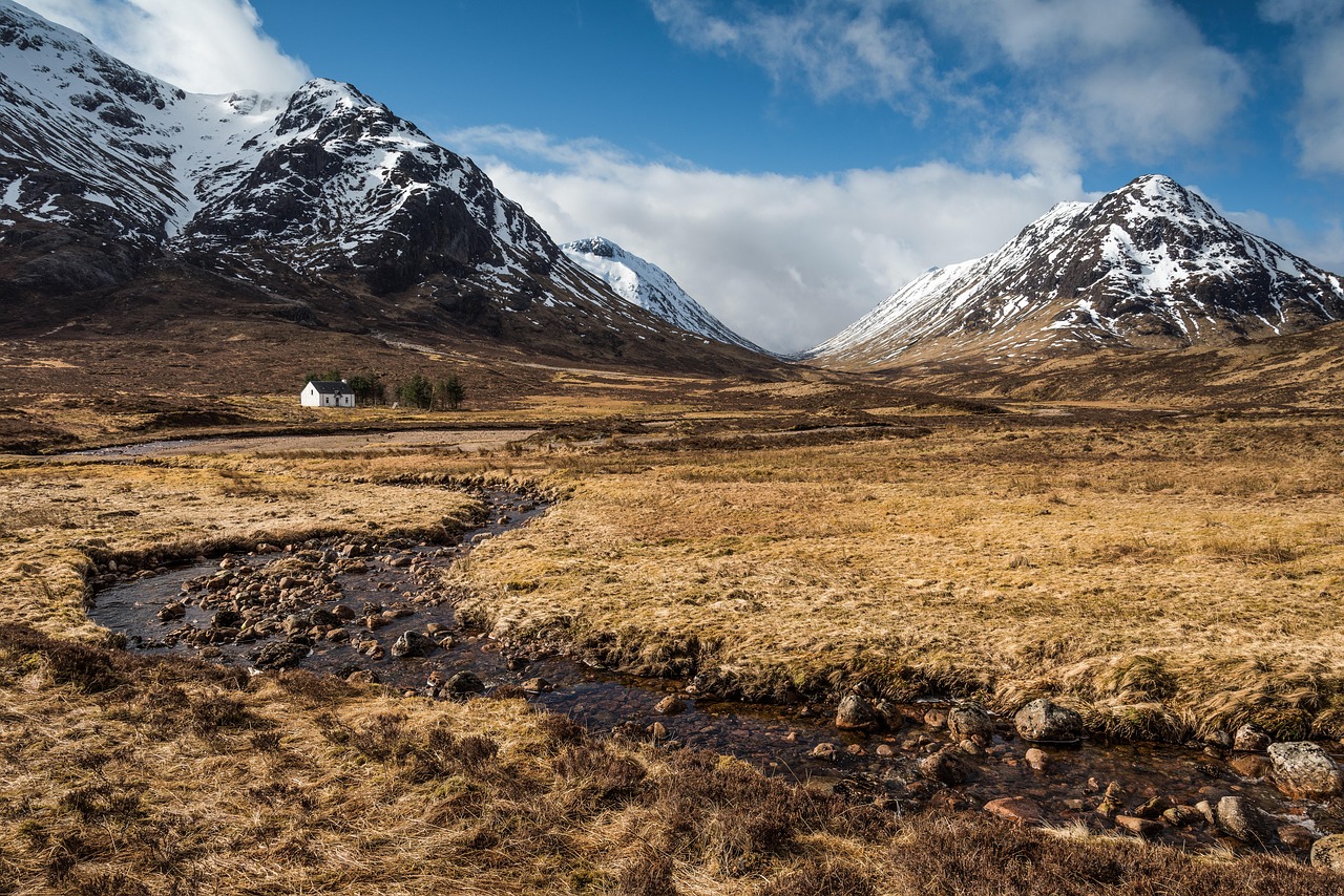 A river flowing through a brown mountain valley in Glencoe Scotland