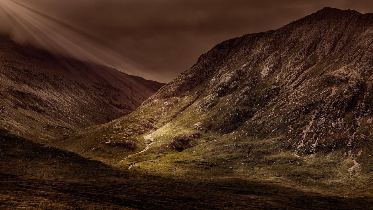 Sunlight breaking through clouds over Glencoe valley in the Scottish Highlands