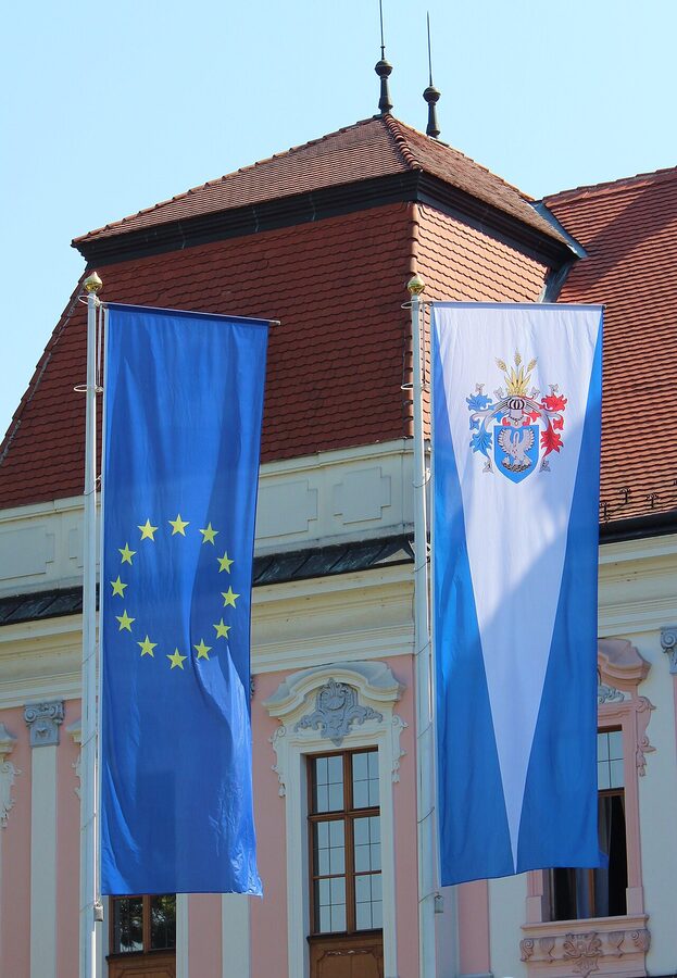 Gödöllő Palace exterior with EU and Gödöllő flags flying