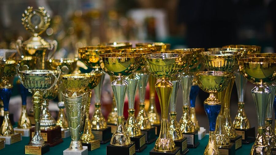 Golden trophy collection on display in a row