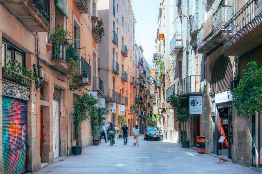 Colorful narrow street in Barcelona Gothic Quarter with pedestrians