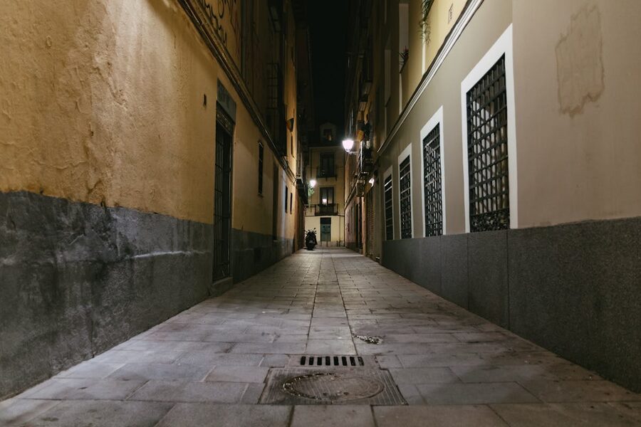 Dimly lit narrow alley between buildings at night
