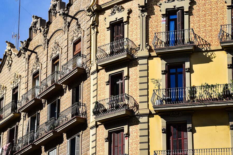 Ornate balconies on sunlit street in Barcelona Gothic Quarter