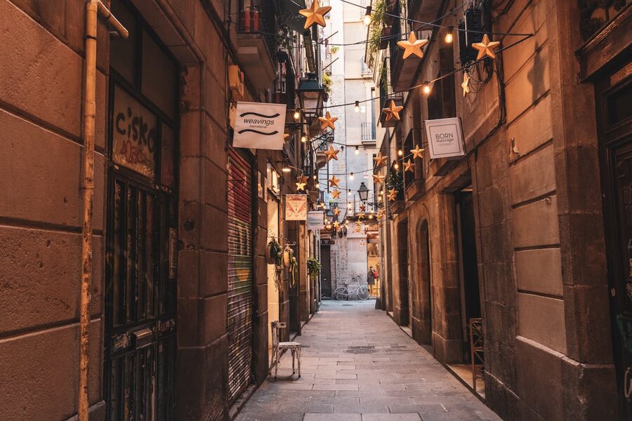 Barcelona alley decorated with star-shaped string lights between old buildings