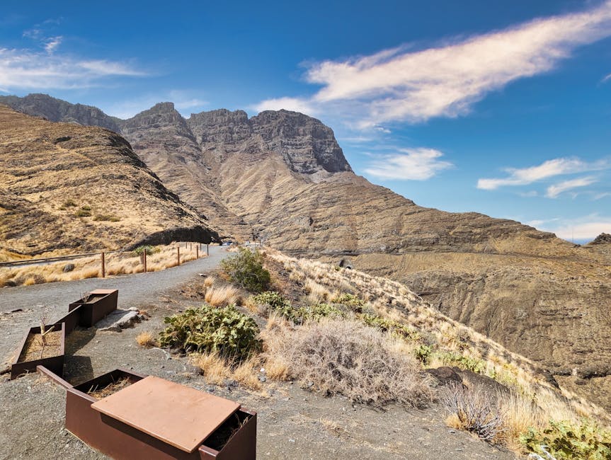Hiking path through rugged mountain terrain in Gran Canaria under blue skies