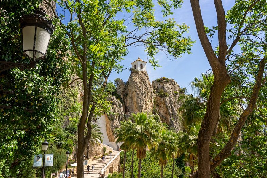 Guadalest bell tower perched on a rocky cliff surrounded by green vegetation