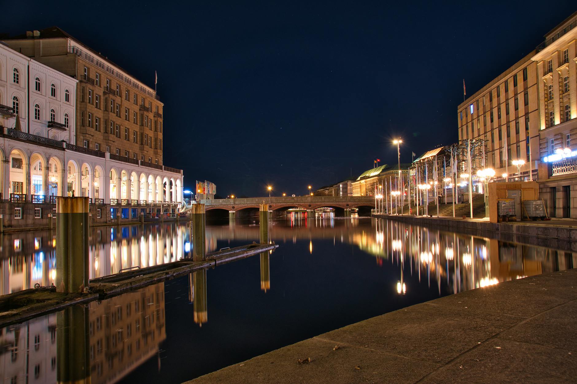 Hamburg canal at night with reflections of illuminated buildings