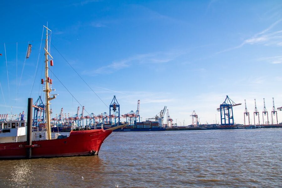 Hamburg harbor red sailboat and cranes