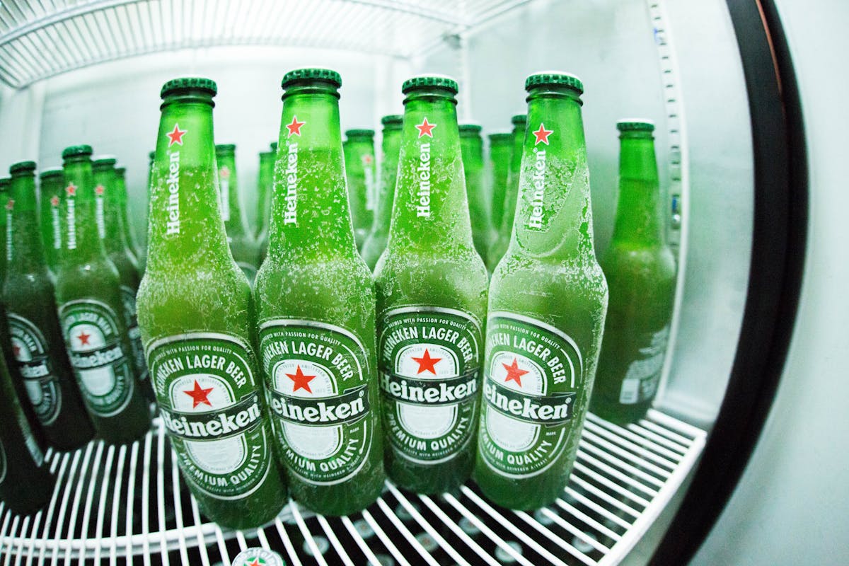 Frosted Heineken beer bottles displayed in a refrigerator