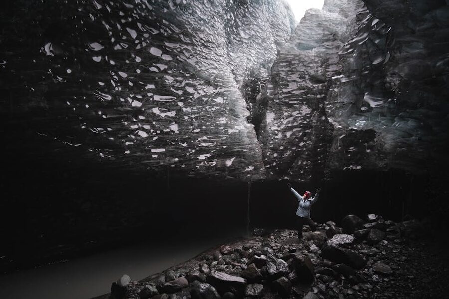 Hiker inside ice cave Iceland glacier