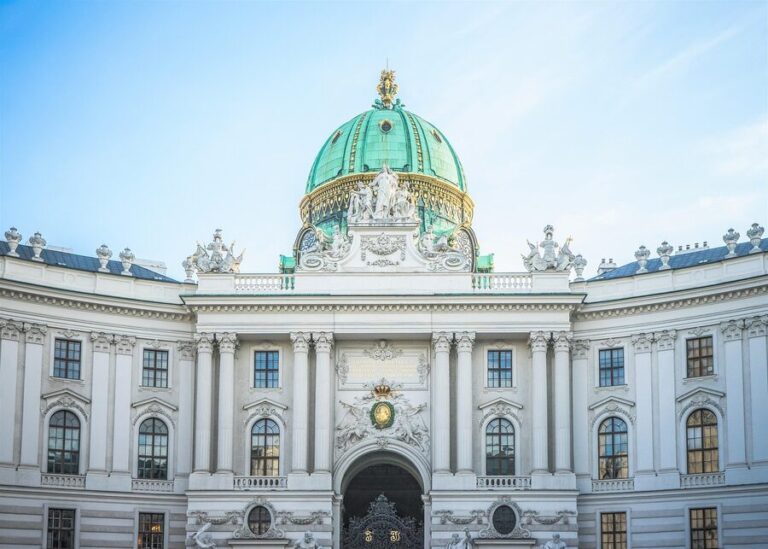 The grand facade of the Hofburg Imperial Palace in Vienna with its green dome and baroque architecture