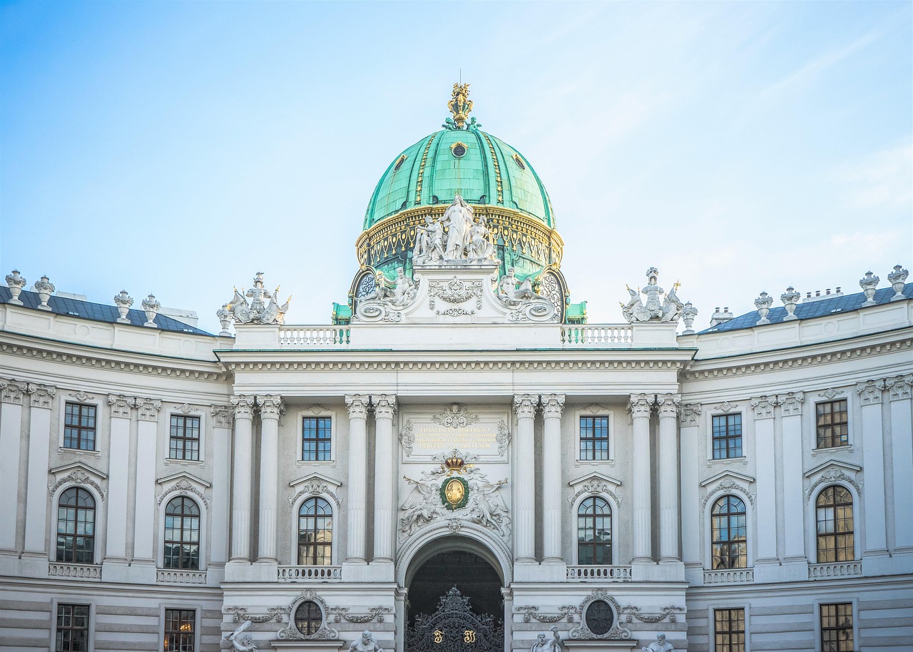 The grand facade of the Hofburg Imperial Palace in Vienna with its green dome and baroque architecture