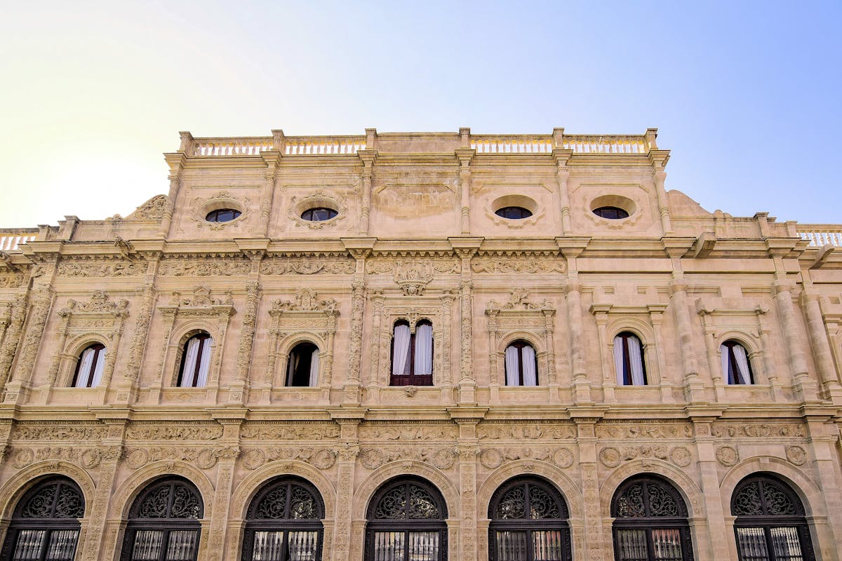The ornate facade of Seville City Hall showing detailed Plateresque architecture in sunlight