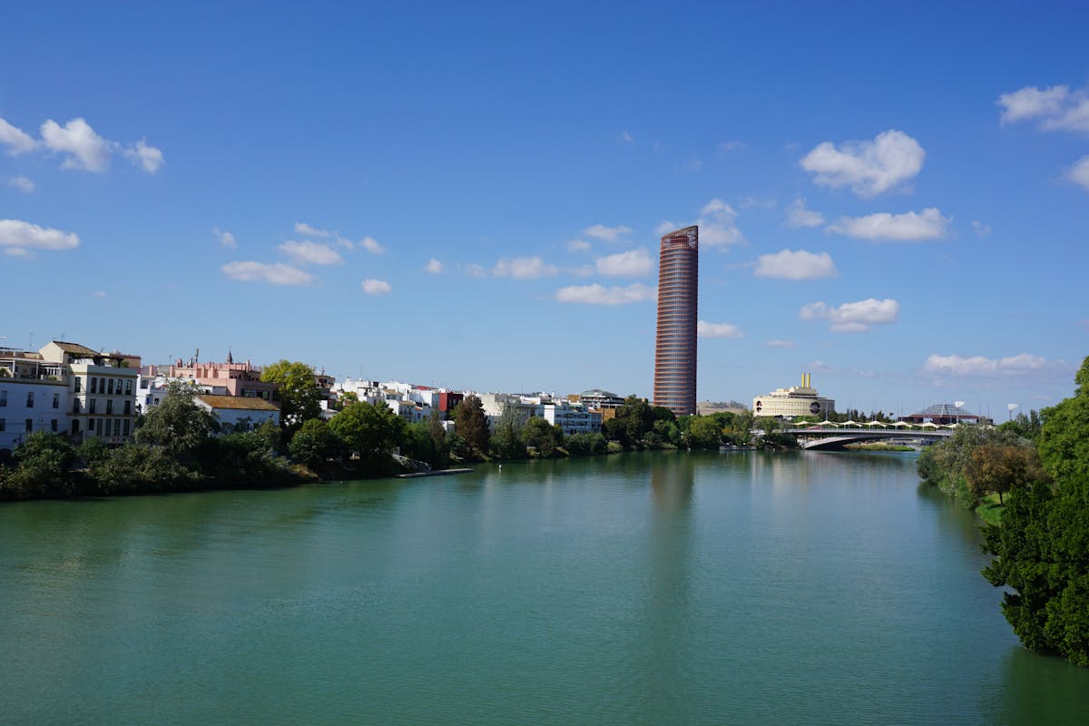 Torre Sevilla skyscraper overlooking the Guadalquivir River under a clear blue sky