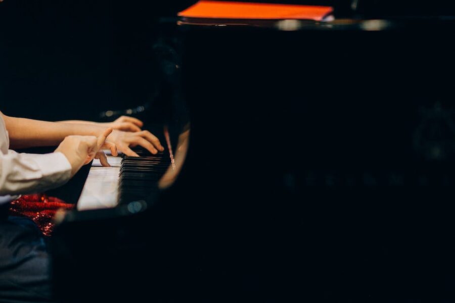 Close-up of hands playing piano keys during a recital