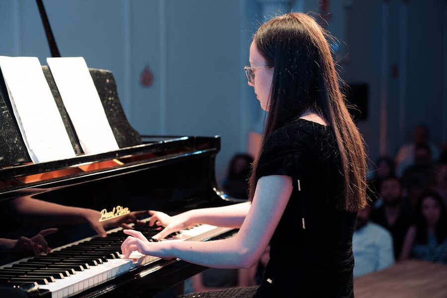 Young woman performing on a grand piano during a live recital
