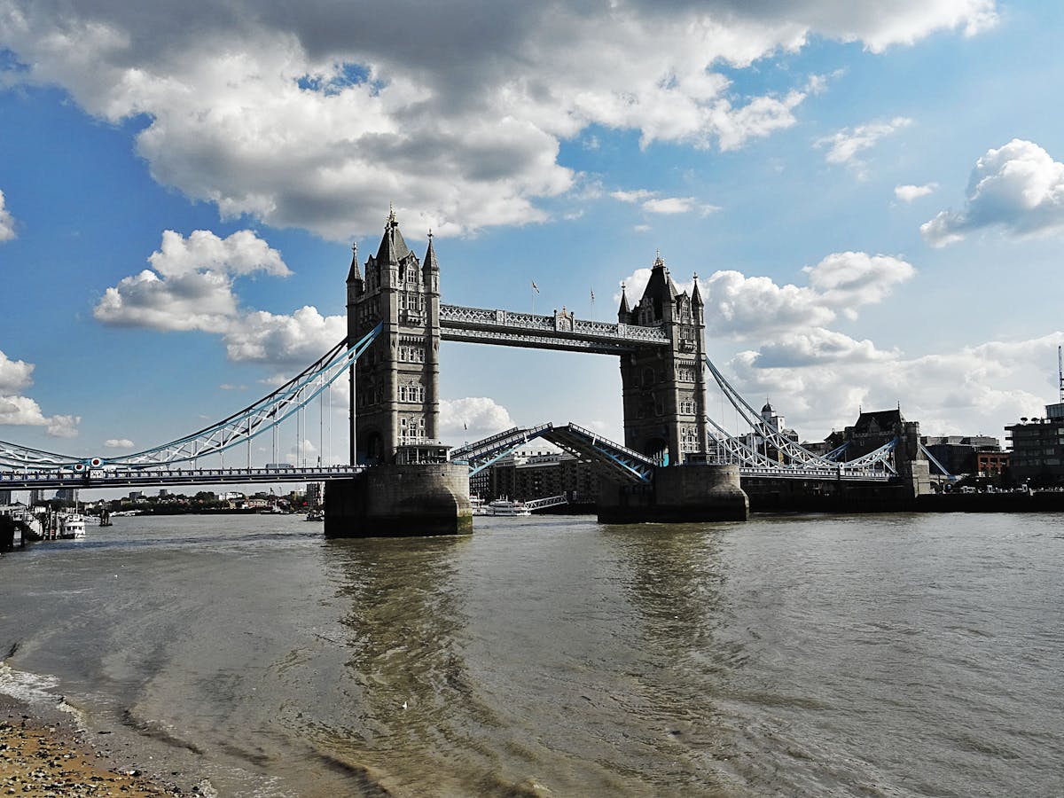 Tower Bridge in London with its bascules raised over the River Thames