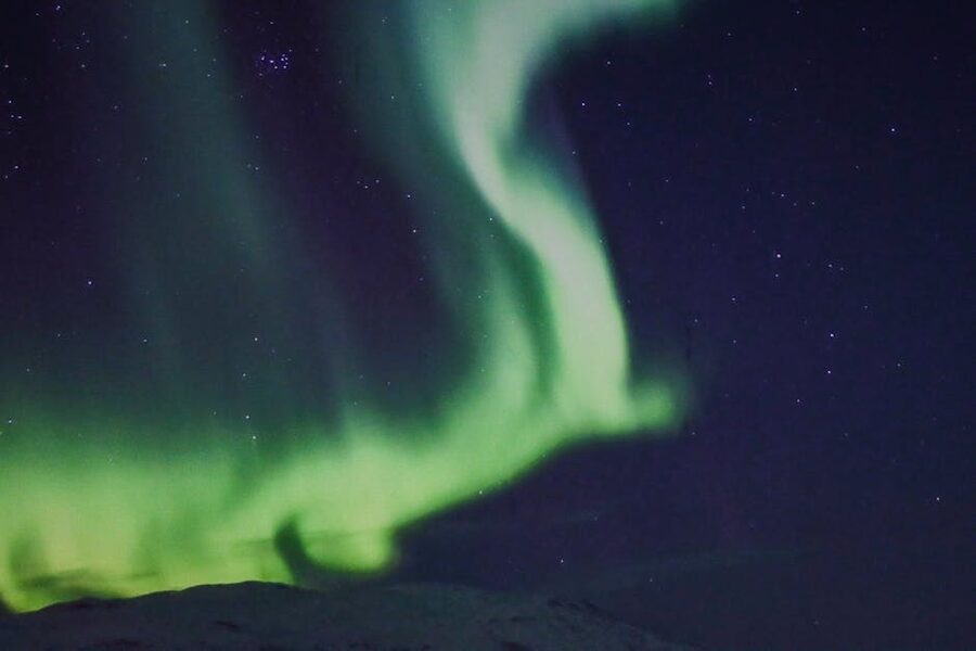 Green aurora borealis dancing over Tromso Norway