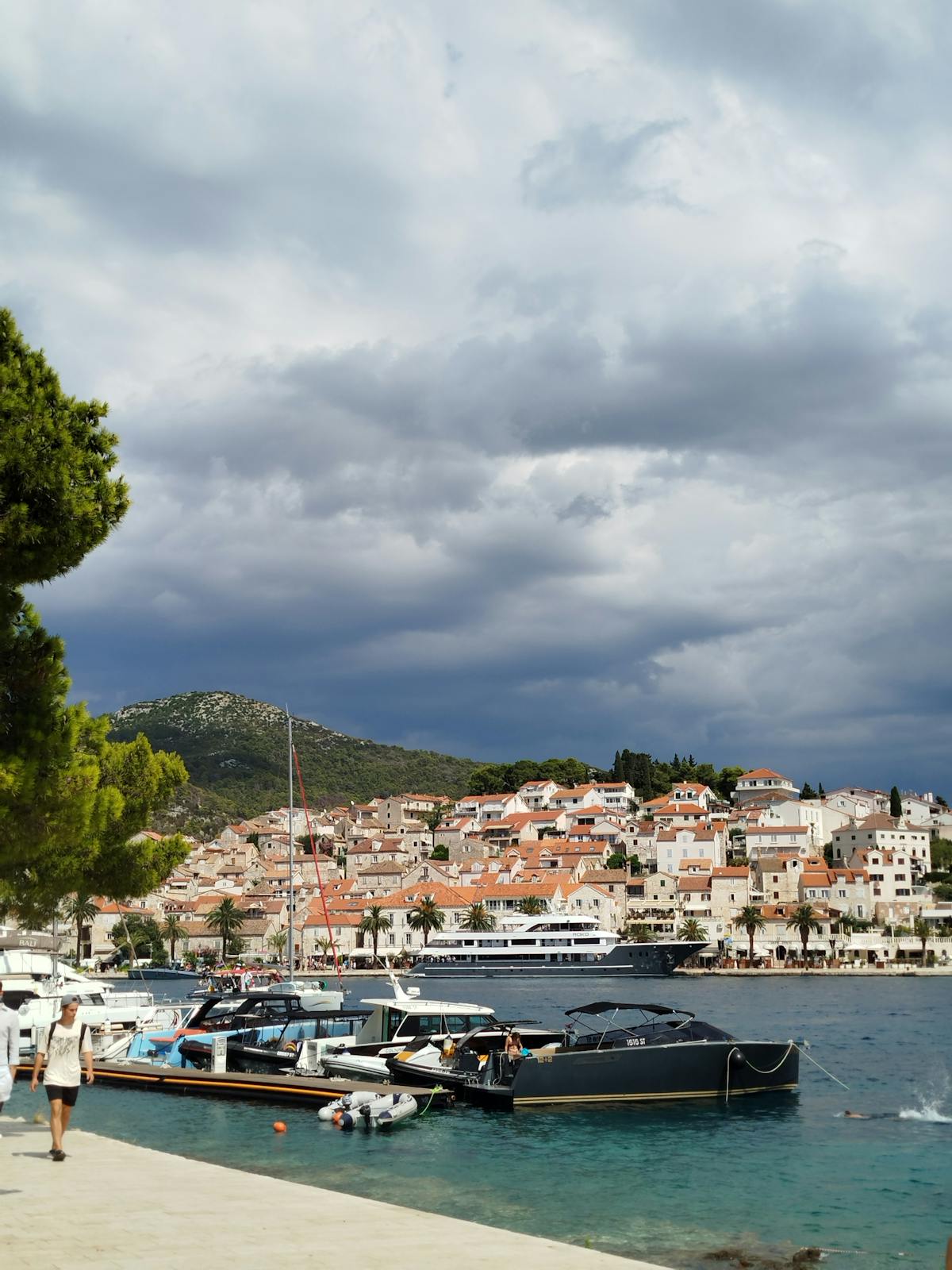 Boats docked in Hvar harbour under dramatic skies