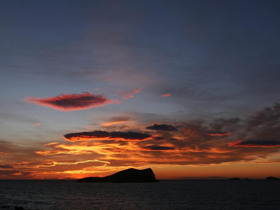 Dramatic sunset over Cala Comte beach in Ibiza with clouds and sea view