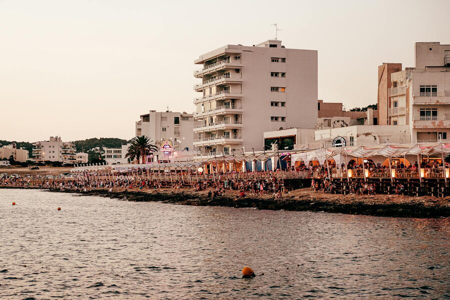 Ibiza waterfront area with coastal bars and buildings lit at sunset