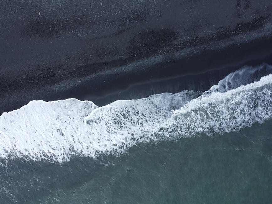 Aerial Iceland black sand beach with waves