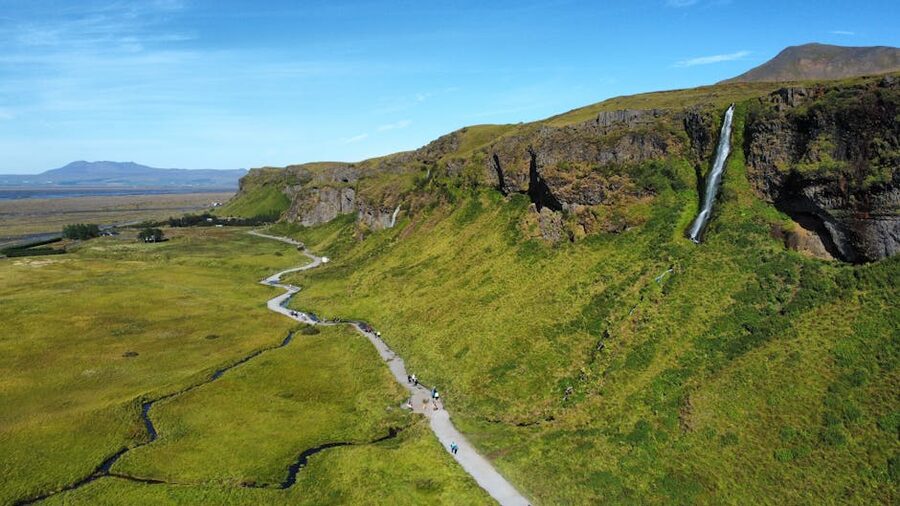 Aerial waterfall cascading Iceland green landscape