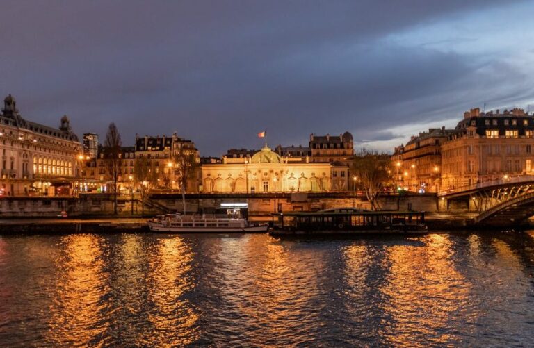 Paris Seine River at night with illuminated bridges and landmarks reflecting on the water