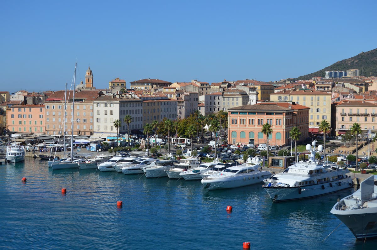 Ajaccio harbour with boats moored along the waterfront and mountains rising behind the town