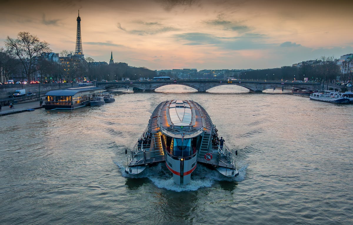 Cruise boat on the Seine River with Eiffel Tower in the background at sunset