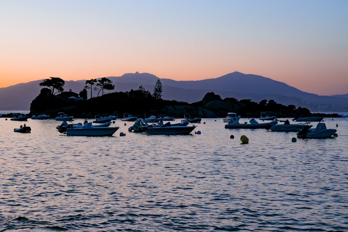 Sunset over Ajaccio bay with boats silhouetted against the orange sky