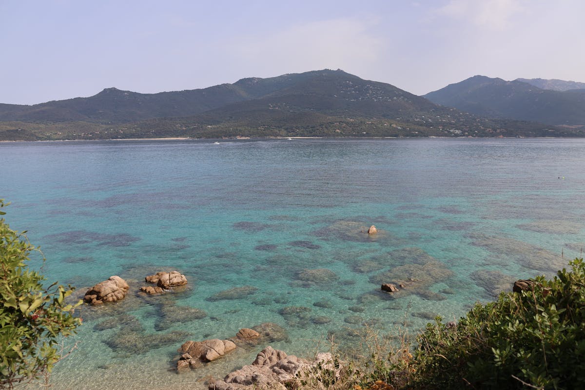 Turquoise waters along the Corsican coastline with rocky outcrops