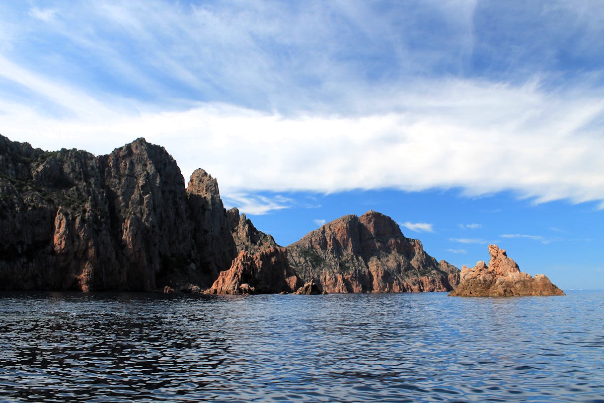 Red volcanic cliffs of Scandola Nature Reserve rising from the Mediterranean