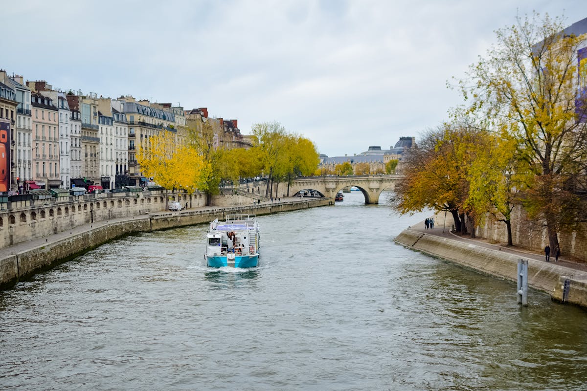 Seine River cruise boat passing under a bridge in Paris