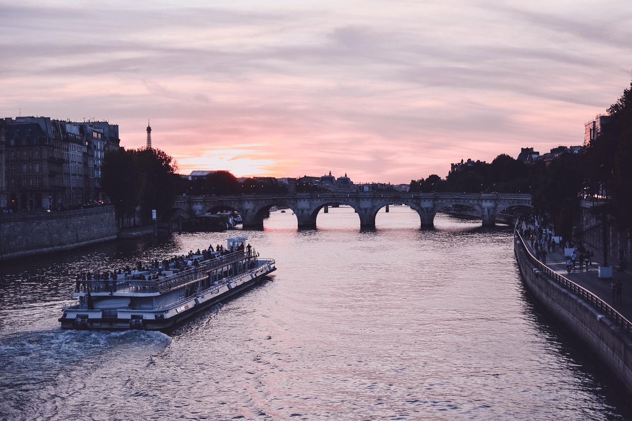 View of Paris Seine river at golden hour with boat and Eiffel Tower