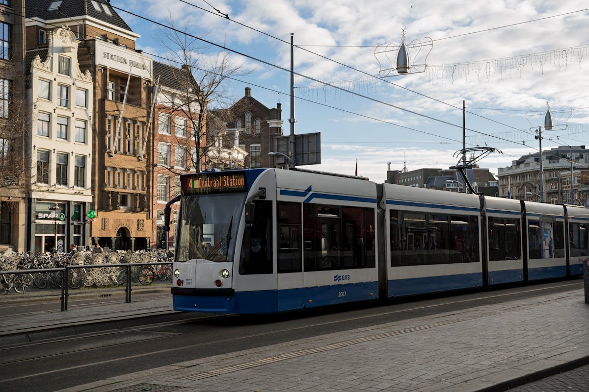Tram in front of Amsterdam Centraal Station with urban architecture