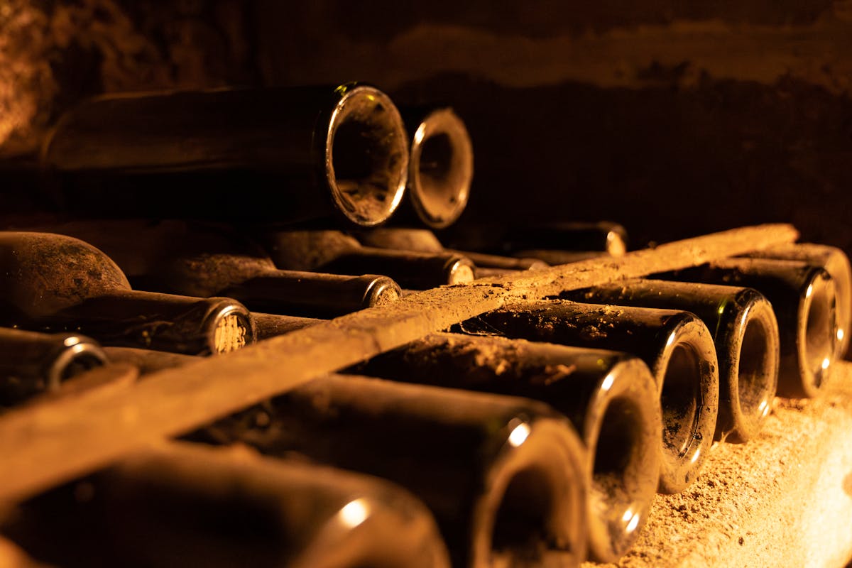 Dusty wine bottles aging in a Bordeaux cellar